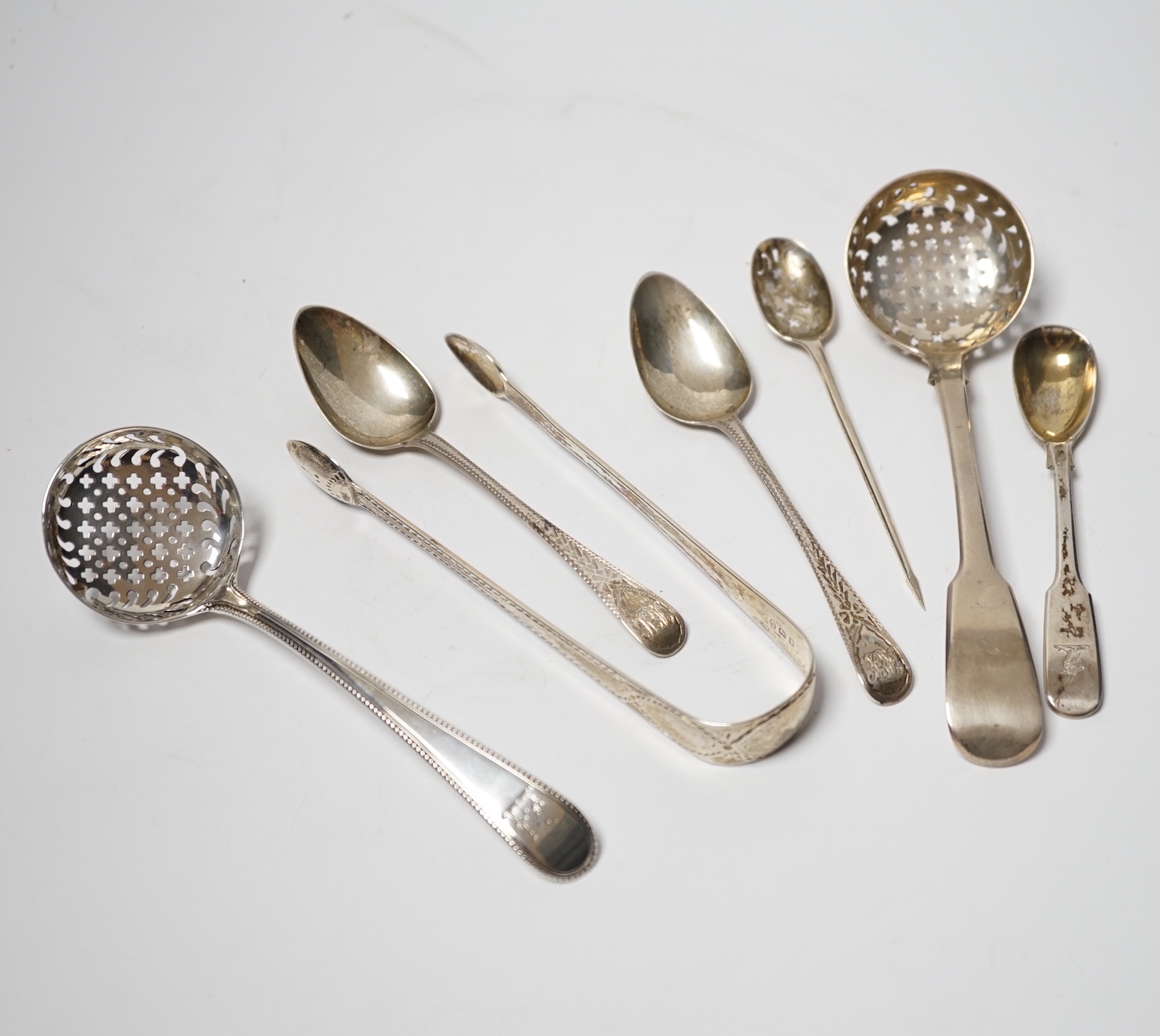 An 18th century silver mote spoon, marks rubbed, 11.8cm and five other various silver spoons and a pair of silver sugar tongs, 5.1oz.